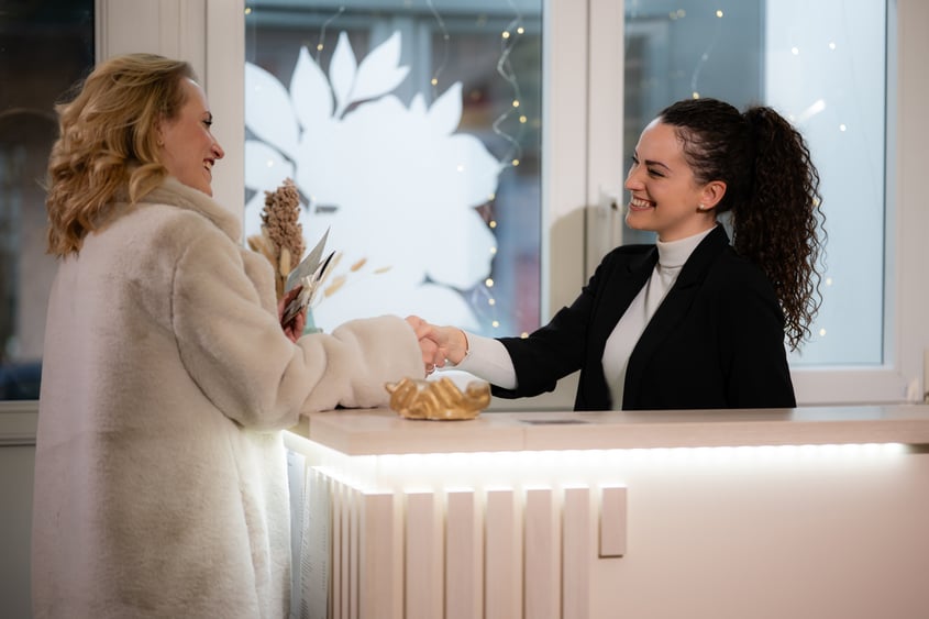 Businesswomen shaking hands at reception desk